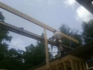 Carpenter setting a ridge beam over a new addition frame — Ice Dam Removal by Roofing Brothers in Agate