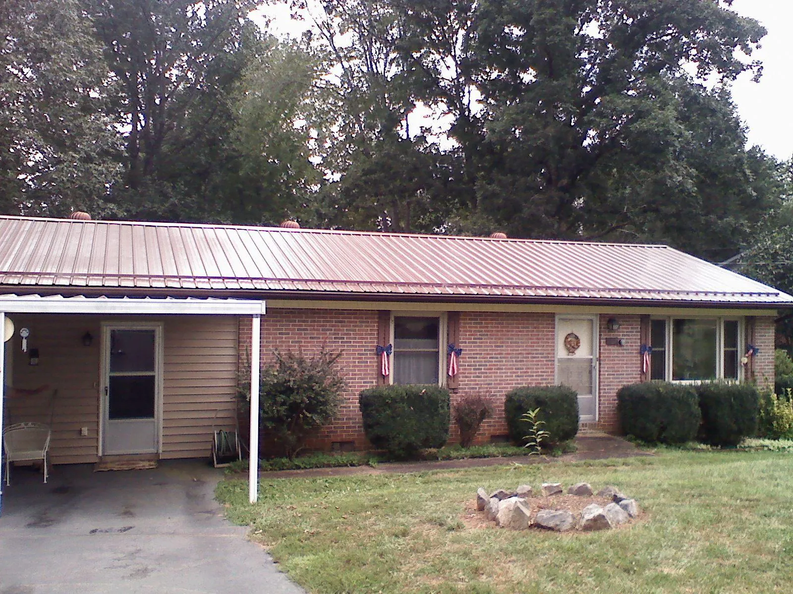 Bronze metal roof and carport on a brick ranch home — Roof Repair work by our crew in Agate