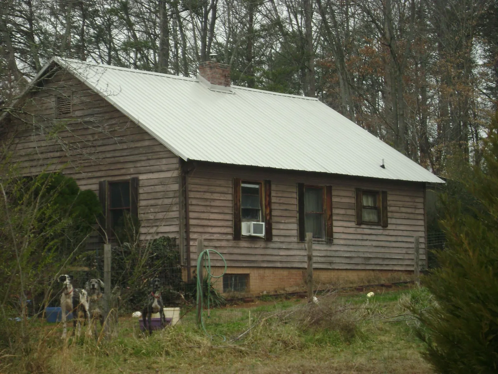 White metal roof on an old wood sided farmhouse, from a Metal Roof Installation job in Agate